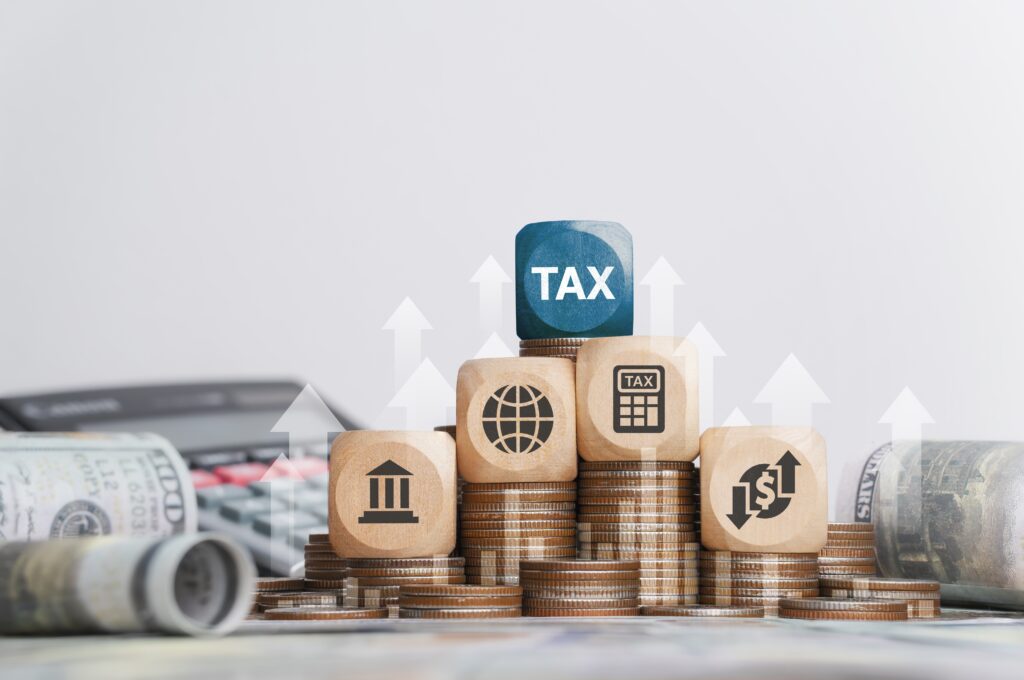 Tax concepts represented by wooden blocks and coins, featuring symbols for global income, tax calculations, and financial institutions. Perfect for understanding personal services income, foreign income tax offset, and navigating tax obligations on foreign income for returning Australians.